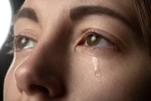 sad woman crying on black background, looking up, closeup portrait