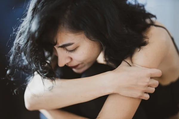 a woman hugging her arm