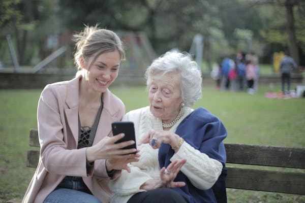 a woman showing a phone to an old woman