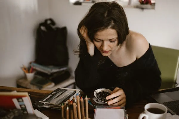 A girl setting in front of of table and wearing black top having Hypertension