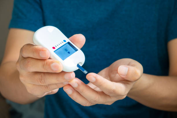 A woman draws blood on his finger and tests it for Diabetes mellitus. Check high blood sugar levels with a digital blood sugar tester. Health care and medical concept