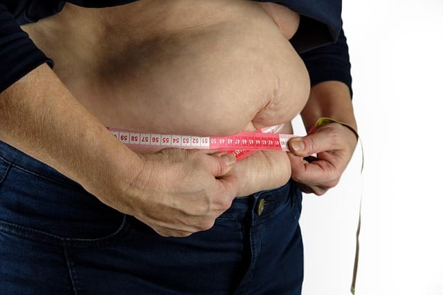 A womeen measuring her belly